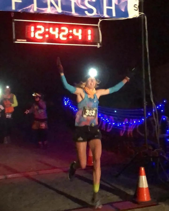 Camille Herron celebrating beneath the finish clock after her 2017 world record