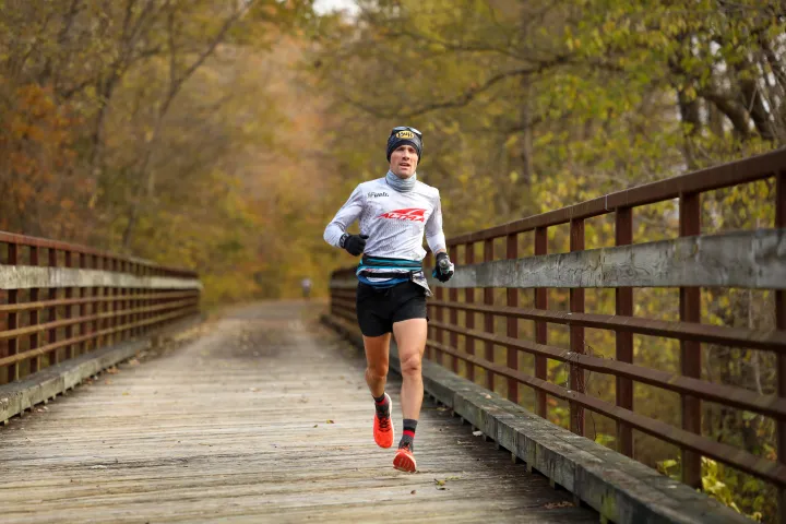 Zach Bitter running across a bridge on the Tunnel Hill trail